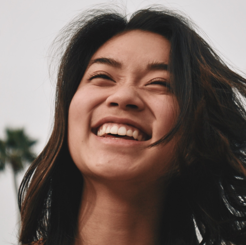 asian woman smiling intensely with medium short brown hair
