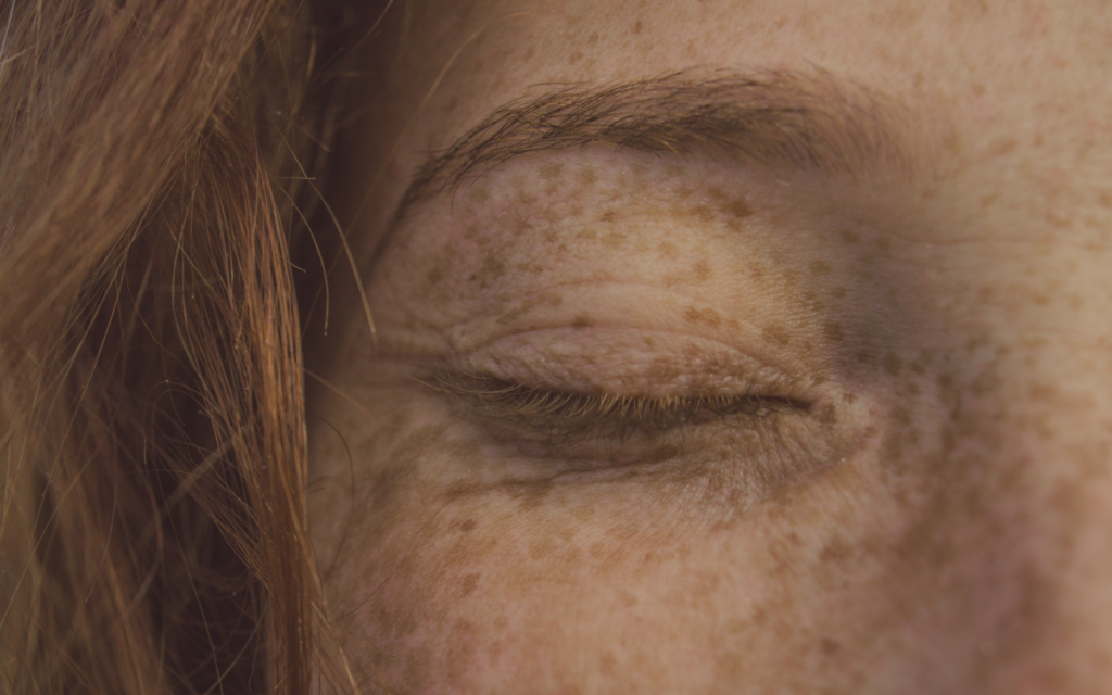 close up of red headed woman with eyes closed