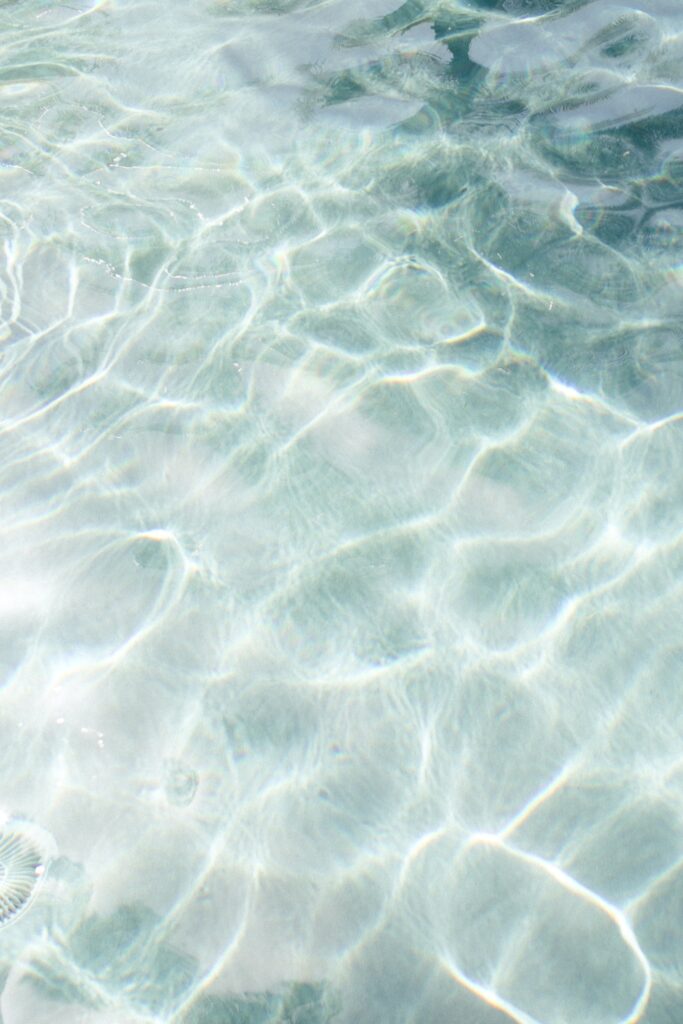 clear blue water with suns reflecting off water ripples