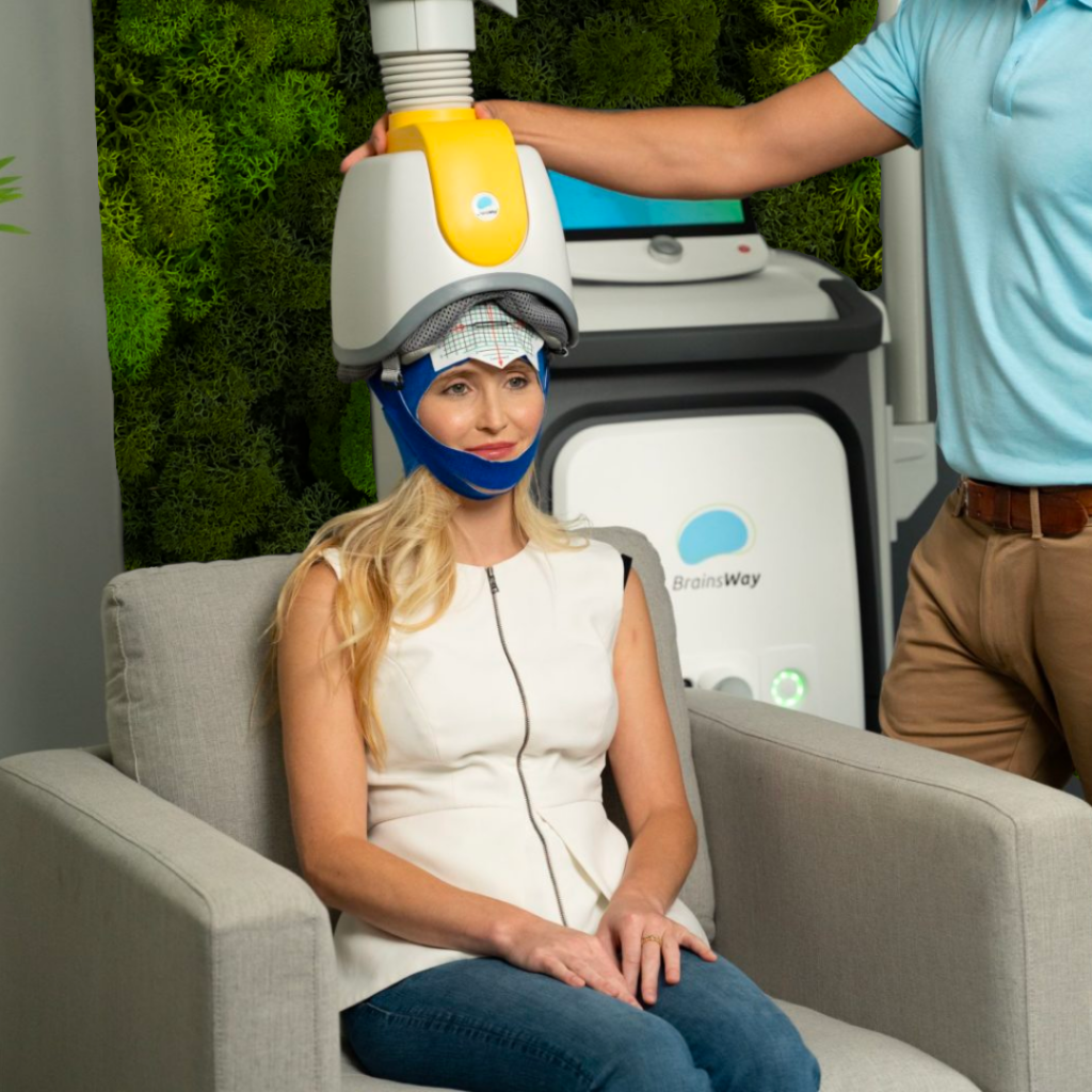 Patient wears TMS helmet while receiving transcranial magnetic stimulation therapy at Hudson Mind. 
